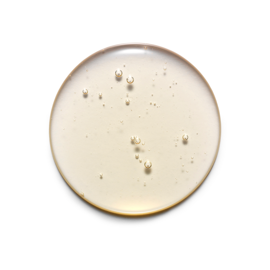 Round ceramic plate with gold rim and scattered pearls on a white background