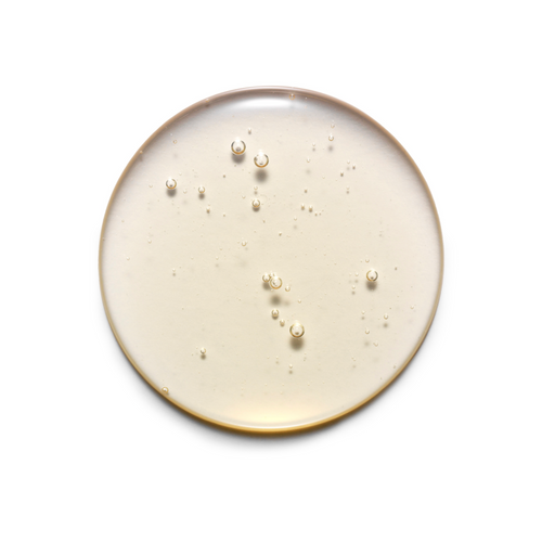 Round ceramic plate with gold rim and scattered pearls on a white background