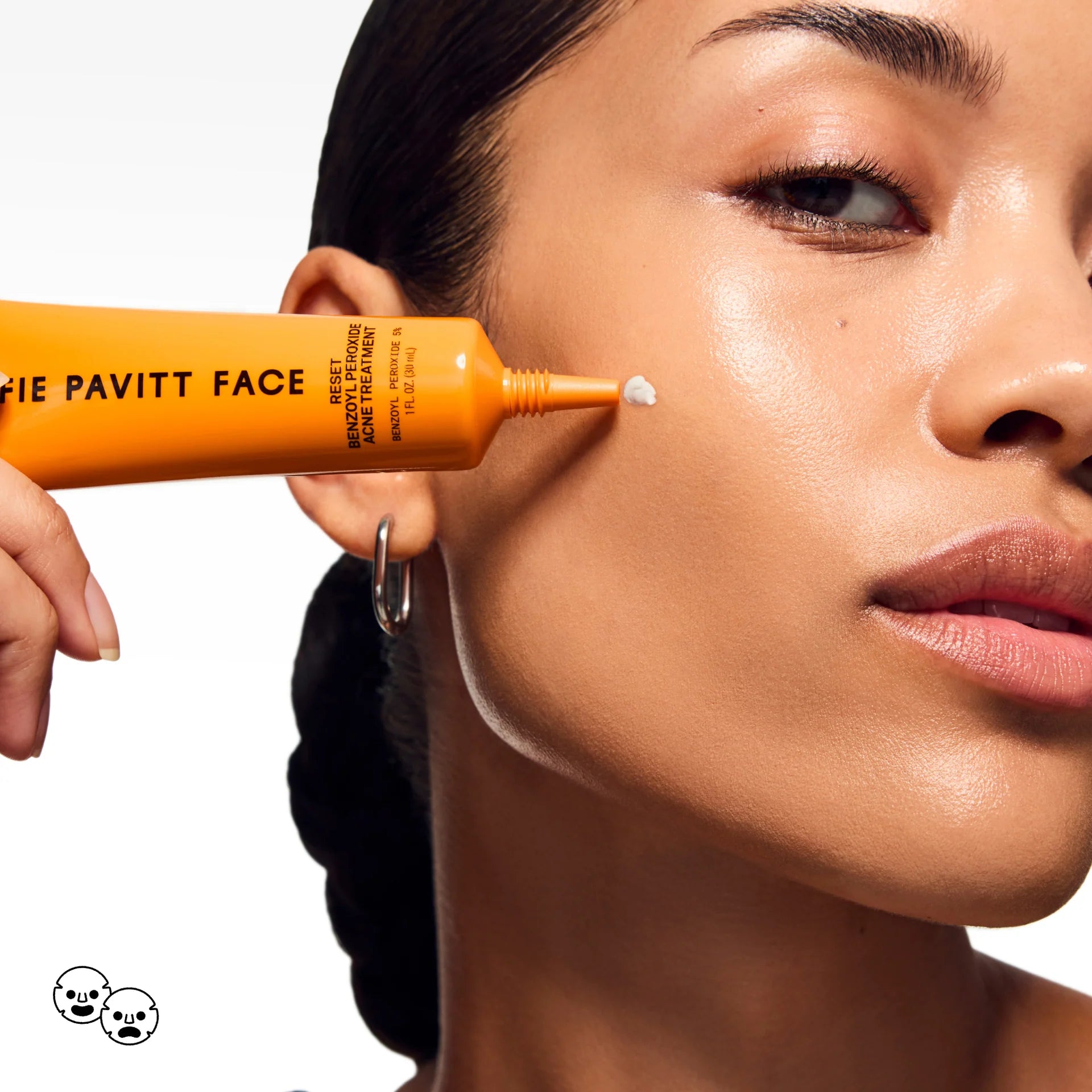 Person applying a product to their face with an orange tube labeled 'Sofie Pavitt Face'.