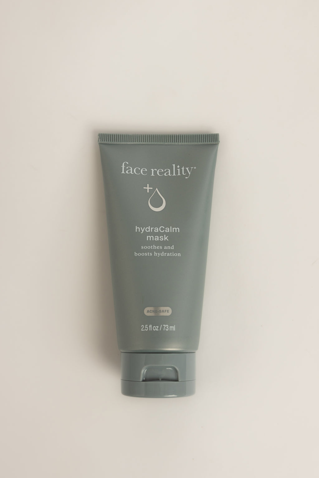 Blue Face Reality HydraCalm Mask tube with white text, standing upright on a light gray background, net weight 2.5 fl oz (73 ml)