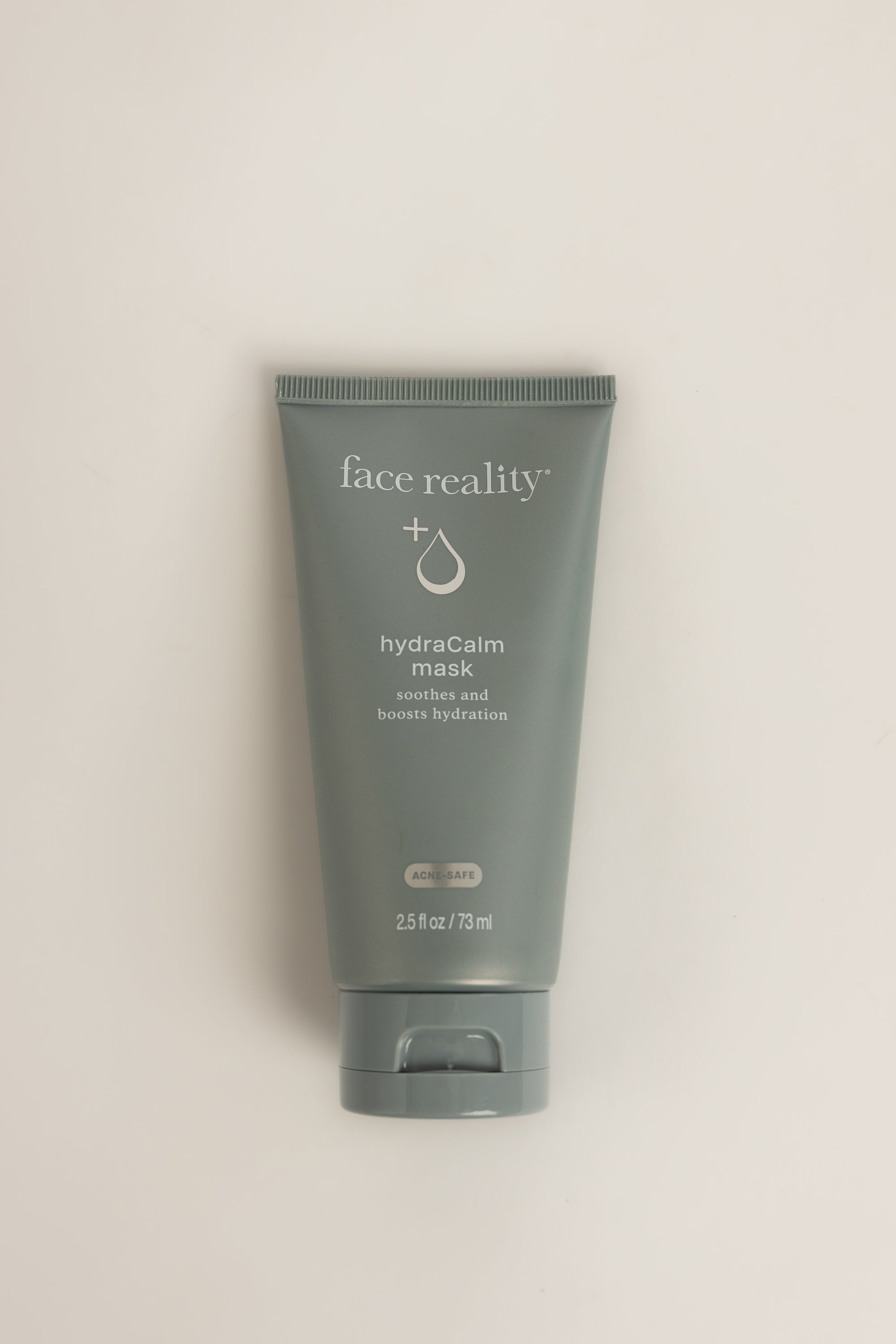 Blue Face Reality HydraCalm Mask tube with white text, standing upright on a light gray background, net weight 2.5 fl oz (73 ml)