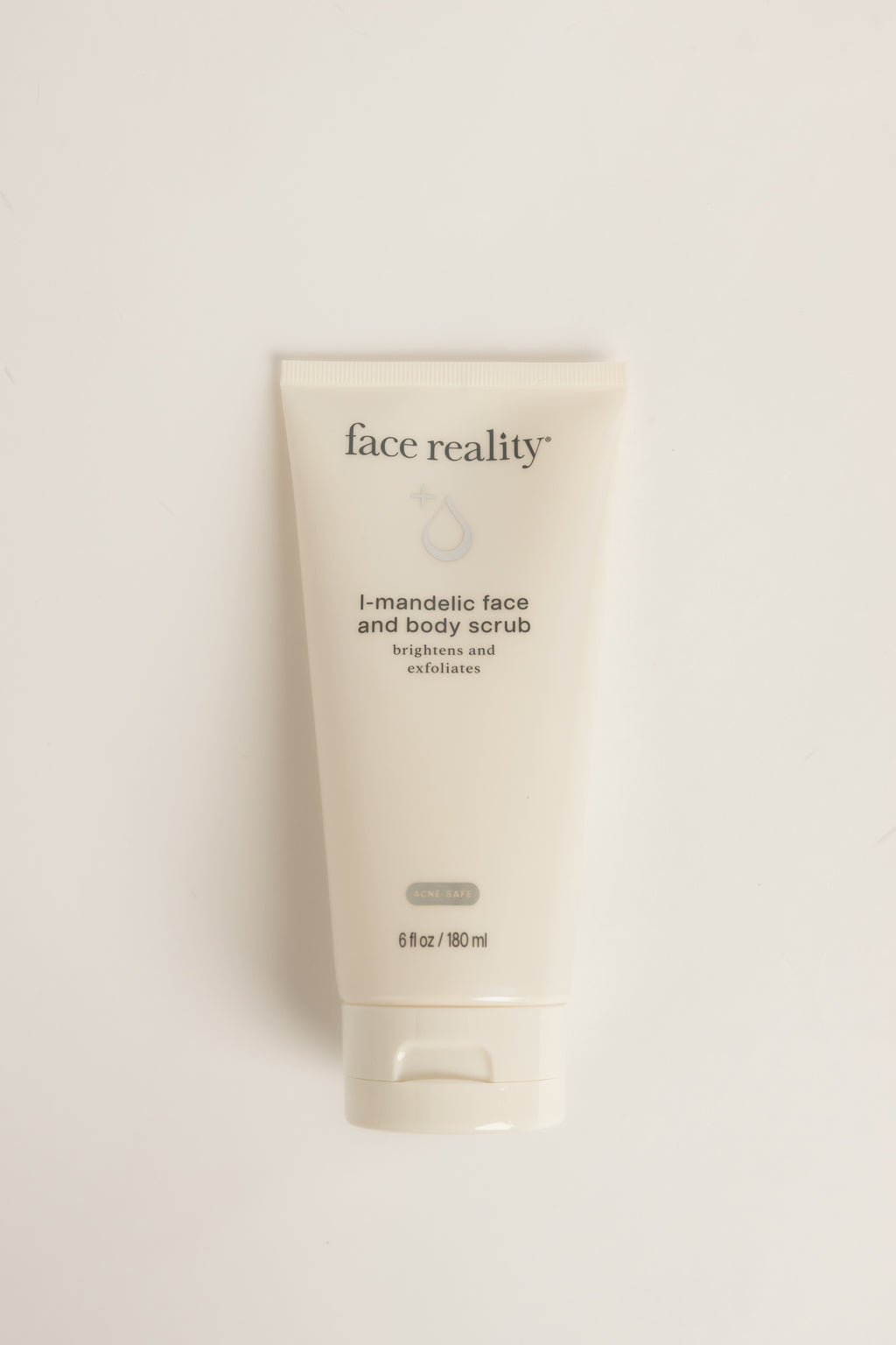 Cream-colored Face Reality L-Mandelic Face and Body Scrub tube with dark text, standing upright on a light background, net weight 6 fl oz (180 ml)